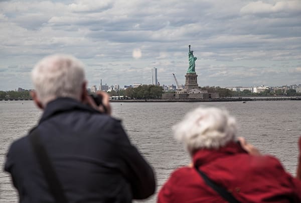 Two seniors photographing the Statue of Liberty