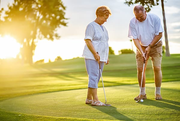 A senior couple golfing